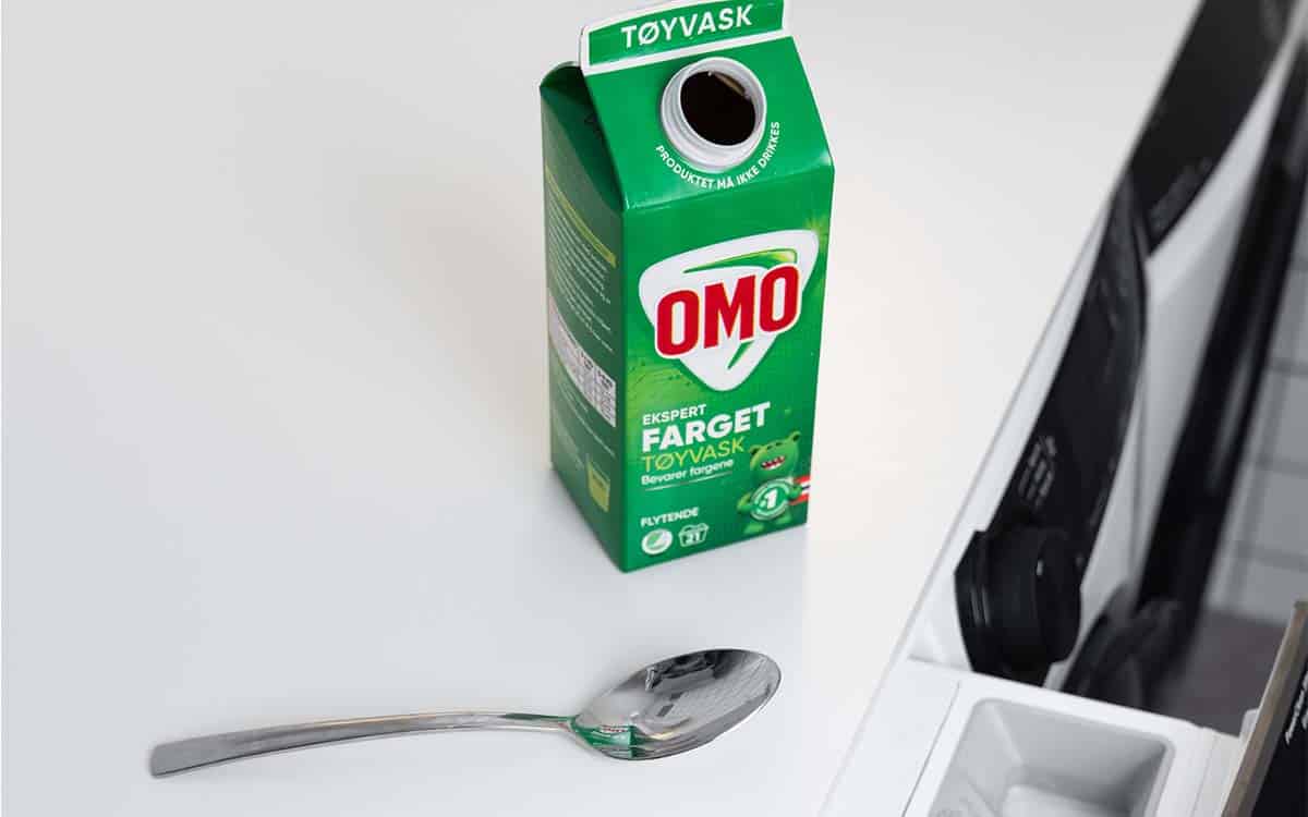 OMO Color og en spiseskje på en vaskemaskin. Slik bruker du den.