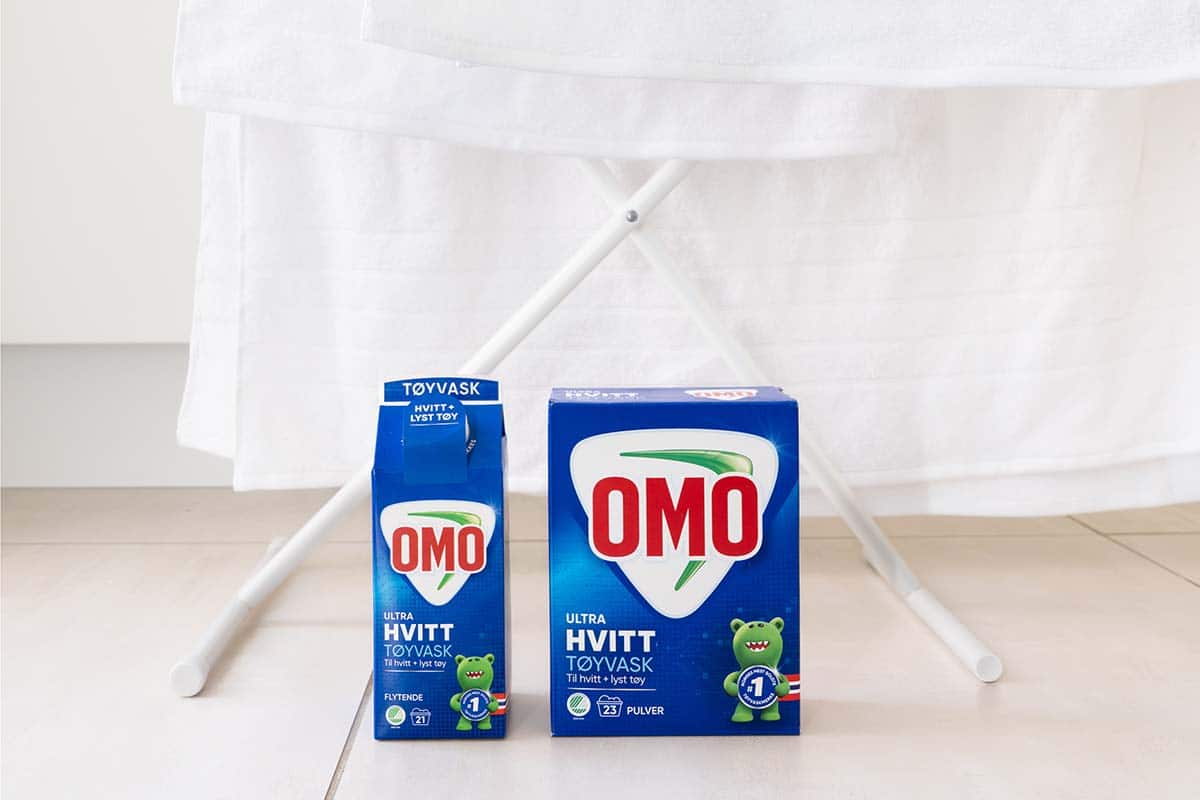 Illustrere å tørke klær: Klær henger til tørk bak OMO-produkter.
