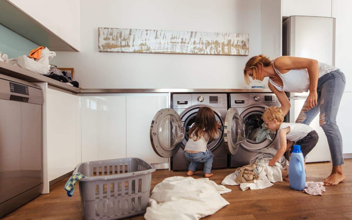 Familien på vaskerommet som bruker ulike vaskeprogram for å vaske klær. FOTO
